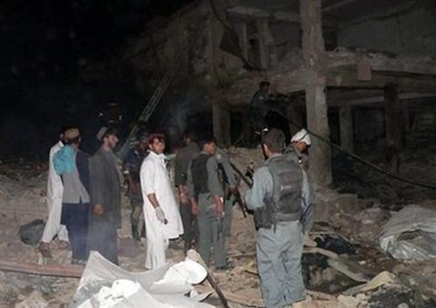 Afghans and policemen at the bomb blast site in Kandahar on ...