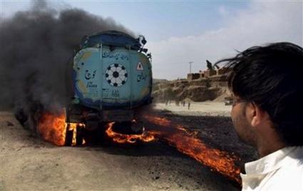 A local resident looks at a burning Pakistani tanker which was ...